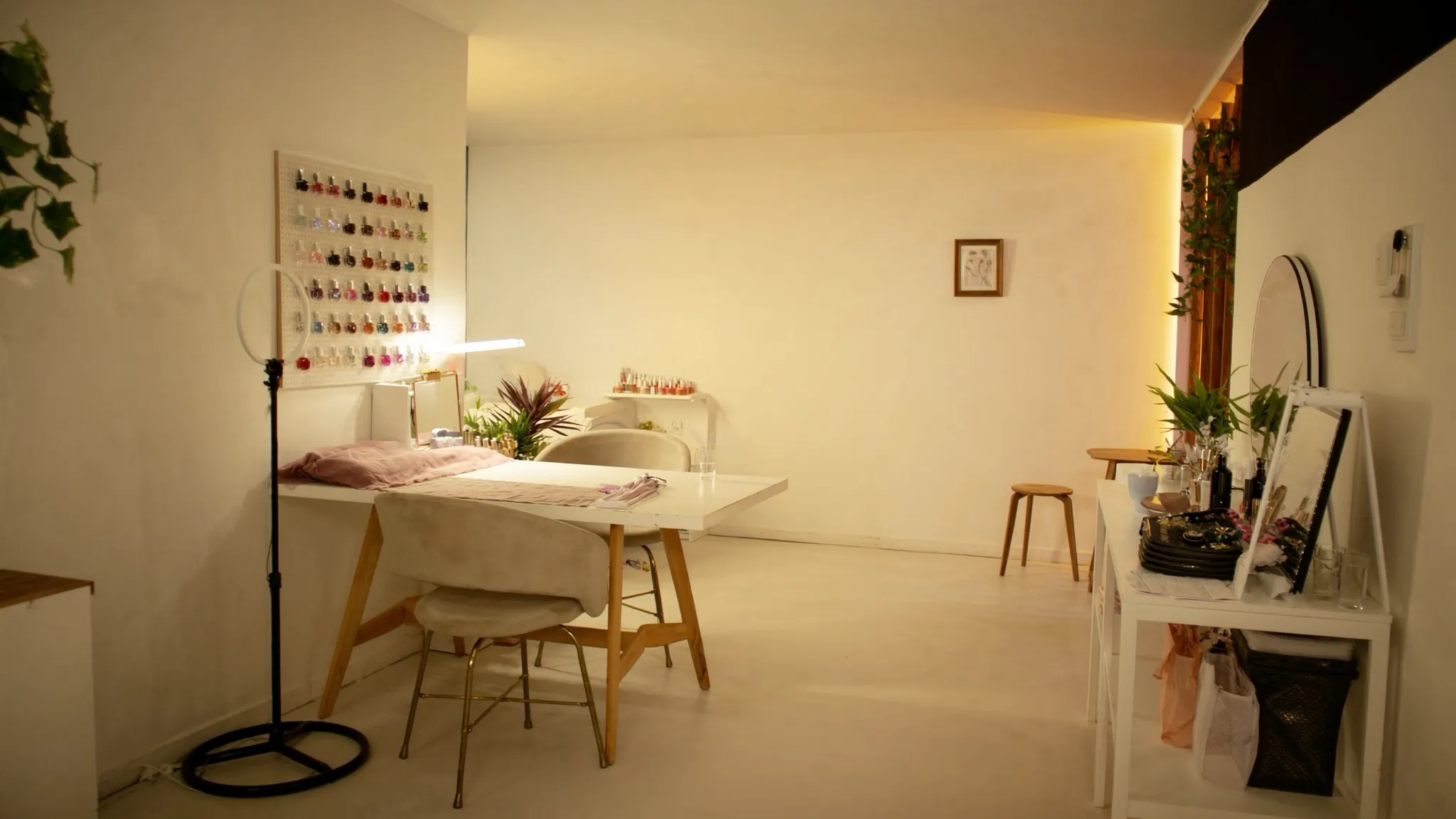 Studio de unhas moderno, organizado e iluminado em tons quentes.